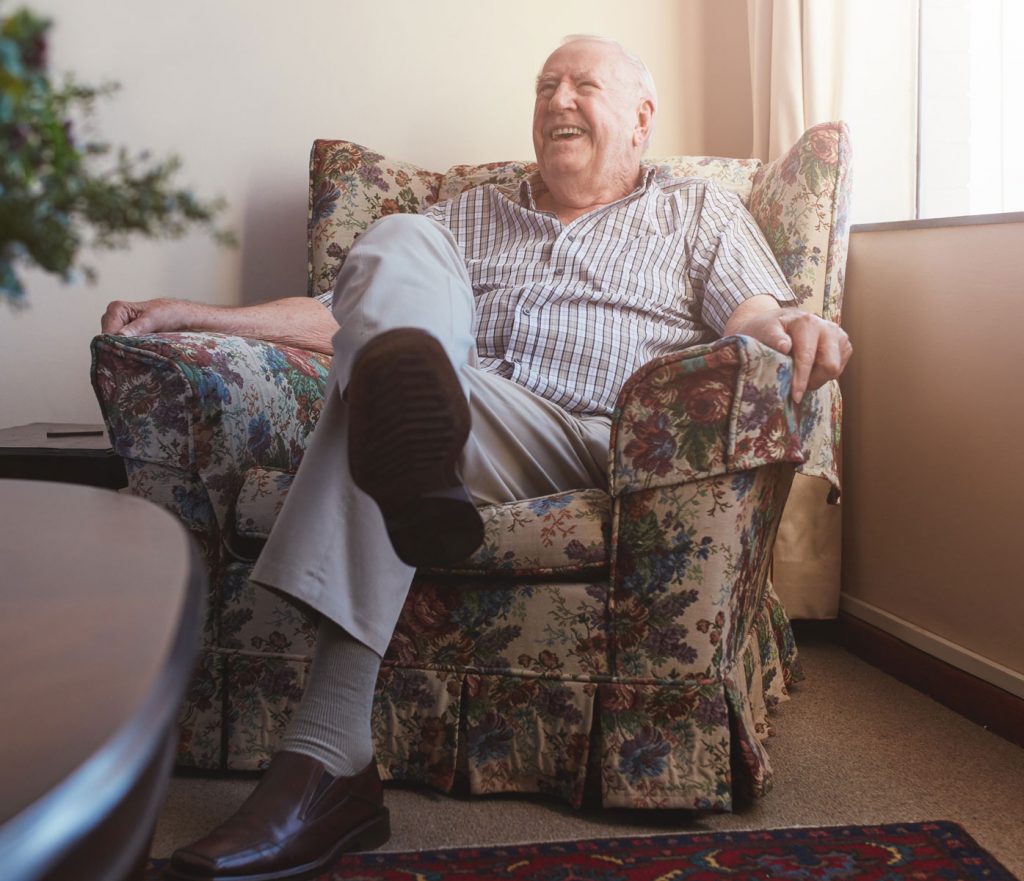 elderly man smiling in a chair